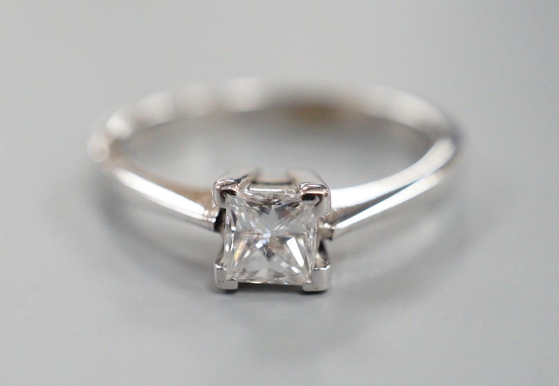 A modern 750 white metal and solitaire princes cut diamond set ring, size L/M, gross weight 2.6 grams
